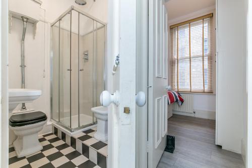 a bathroom with a toilet and a glass shower at Radio Apartments London - Covent Garden in London