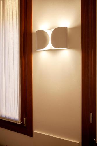 a light on a wall next to a window at Ca' della Scimmia - Rialto Bridge, Venice in Venice