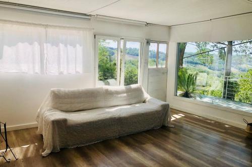een slaapkamer met een groot bed en grote ramen bij Casa Acacia in Fiorenzuola di Focara
