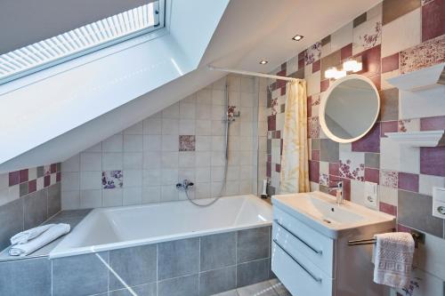 a bathroom with a bath tub and a sink at Ferienwohnung Drosi am Berg in Memmelsdorf