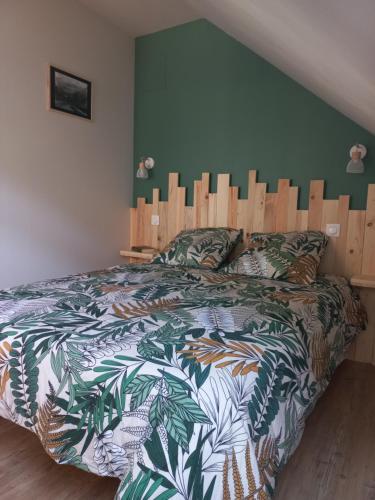 - une chambre avec un grand lit et une tête de lit en bois dans l'établissement Logement entièrement rénové au cœur du Val d'Azun, à Arras-en-Lavedan