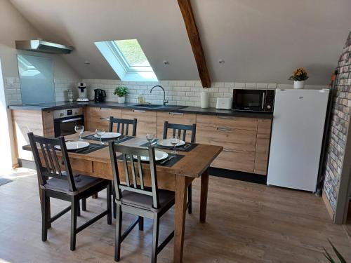 une cuisine avec une table en bois avec des chaises et un réfrigérateur dans l'établissement Logement entièrement rénové au cœur du Val d'Azun, à Arras-en-Lavedan