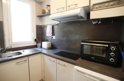 La cuisine est équipée d'un four micro-ondes et d'un évier. dans l'établissement Le Flaugergues centre ville Rodez, à Rodez