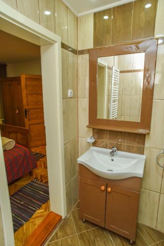 a bathroom with a sink and a mirror and a bedroom at Familija 77 in Kikinda