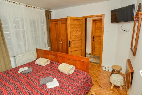 a bedroom with a bed with two towels on it at Familija 77 in Kikinda