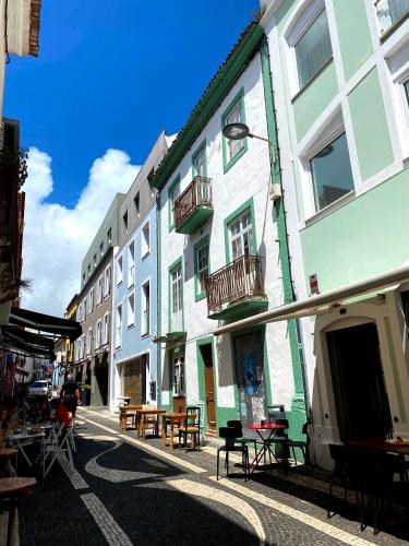 a group of buildings with tables and chairs on a street at Karamba Azores AP central in Ponta Delgada