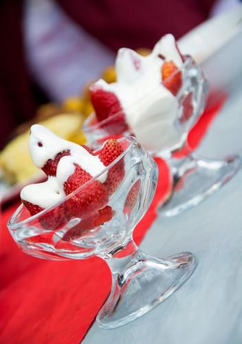 two glass dishes of strawberries and whipped cream on a table at Cabañas y Glampings Balcon del lago in Otavalo