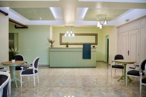 a waiting room with tables and chairs and a projection screen at Imperial Hotel&Spa - Baile Olanesti in Băile Olăneşti