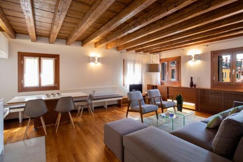 ein Wohnzimmer mit einem Sofa, einem Tisch und Stühlen in der Unterkunft Ca' della Scimmia - Rialto Bridge, Venice in Venedig