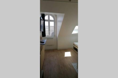 - un salon vide avec une fenêtre et du parquet dans l'établissement Cosy Studio hyper centre 1, à Orléans