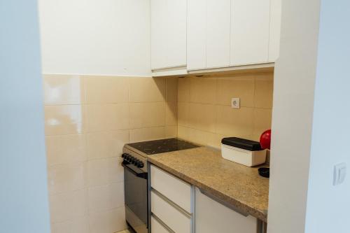 a small kitchen with white cabinets and a stove at Suite Dreams in Valjevo