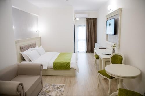 1 dormitorio con cama, escritorio y mesa en Imperial Hotel&Spa - Baile Olanesti en Băile Olăneşti