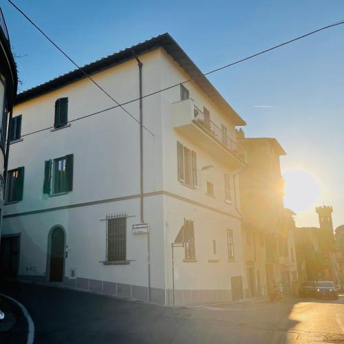 a white building with a balcony on a street at Fiesole's cozy Apartment 1 in Fiesole