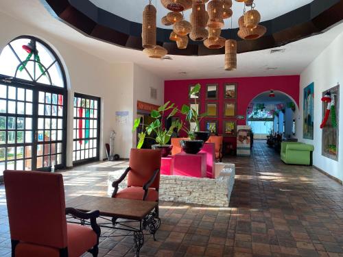 a lobby with pink furniture and a table and chairs at Tropical apartment in Cancún