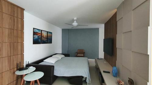 ein kleines Schlafzimmer mit einem Bett und einem TV in der Unterkunft Apartamento Ninho das Gaivotas - Praia dos Anjos Residence - 2 Vagas in Arraial do Cabo