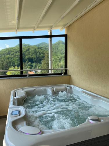 a jacuzzi tub in a room with a window at Imperial Hotel&Spa - Baile Olanesti in Băile Olăneşti