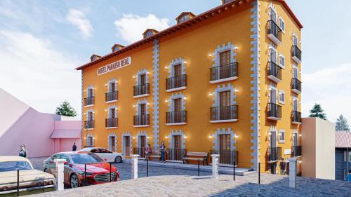 un edificio amarillo con coches estacionados frente a él en Hotel Paraiso Real Plus, en Mineral del Monte