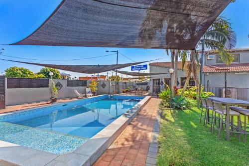 a swimming pool in the backyard of a house at Alabaster Motor Inn in Taree
