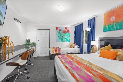 Habitación de hotel con 2 camas, escritorio y sillas en Alabaster Motor Inn en Taree