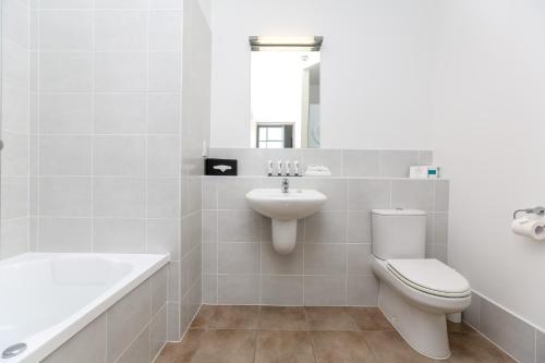 Un baño blanco con inodoro y lavabo. en Quest New Plymouth CBD Apartment Hotel, en New Plymouth