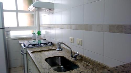 a kitchen counter with a sink and a window at Casa com piscina e churrasq na Praia de Camburí in São Sebastião