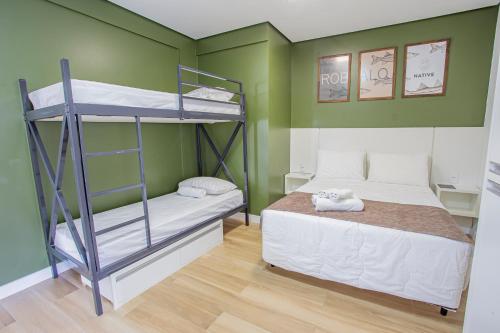 a bedroom with two bunk beds and green walls at Pousada Native in Florianópolis
