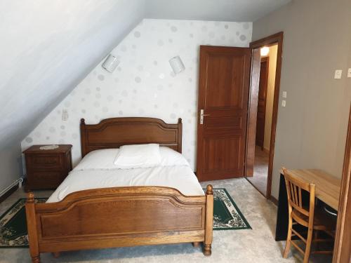 um quarto com uma cama de madeira e uma mesa em le gutty - maison de vacances em Natzwiller