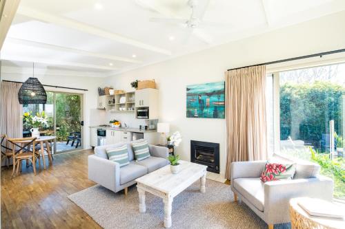 a living room with a couch and a table at Te Awanga Cottages in Te Awanga