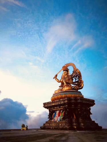 a statue sitting on top of a field at ManBuYunDuan.Theme Inn in Wutai
