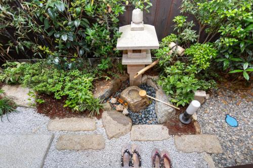 a garden with a bird feeder and some plants at INN Plus General Castle Nijo in Kyoto