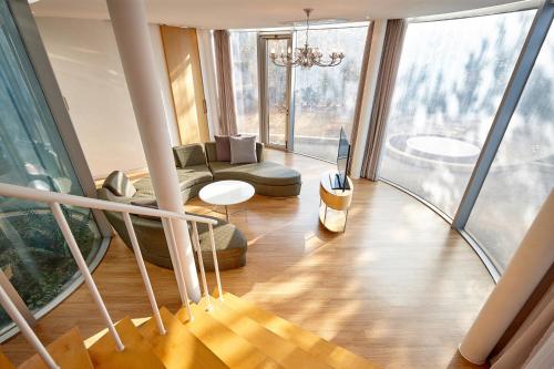 un salon avec un escalier et une grande fenêtre dans l'établissement Lotte Resort Jeju Artvillas, à Seogwipo