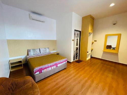 a bedroom with a large bed and a wooden floor at Dz Residence Tunjong in Kota Bharu