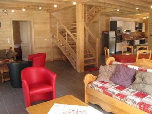 uma sala de estar com cadeiras vermelhas e uma escada em Magnificent wooden chalet with sauna em Ventron