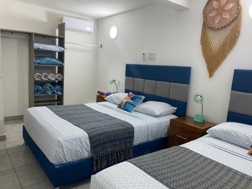 ein Schlafzimmer mit zwei Betten mit blau-weißer Bettwäsche in der Unterkunft blue angel 4 in Playa del Carmen