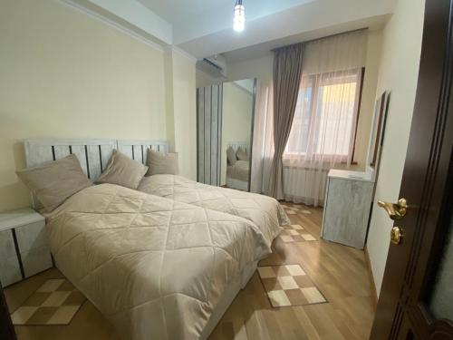 ein Schlafzimmer mit einem weißen Bett und einem Fenster in der Unterkunft Cascade - Opera Apartment in Yerevan