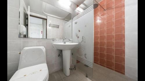 Yeosu Beach Hotel في يوسو: حمام أبيض مع حوض ومرحاض