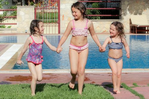 two young girls in bathing suits walking by a pool at Electra Hotel in Stavros