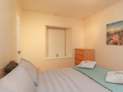 a small bedroom with a bed and a window at Heatherbank in Garelochhead