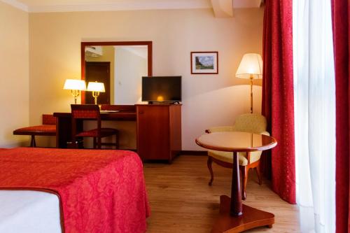 um quarto de hotel com uma cama, uma mesa e uma secretária em Gran Hotel de Ferrol em Ferrol