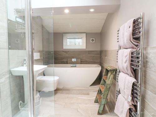 y baño con bañera, aseo y lavamanos. en Hen House View en Rugeley