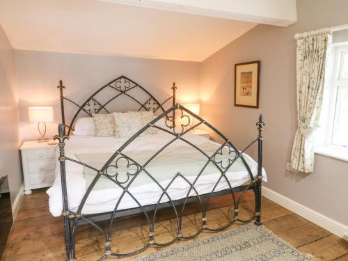 um quarto com uma cama de ferro forjado num quarto em Hen House View em Rugeley