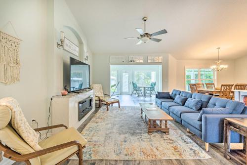 a living room with a blue couch and a tv at Rainbow River Home with Private Kayak Dock in Dunnellon