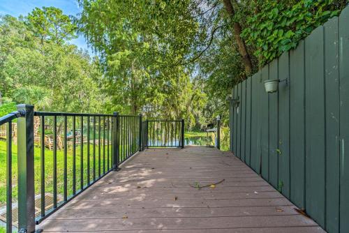 a wooden walkway with a green fence and trees at Rainbow River Home with Private Kayak Dock in Dunnellon