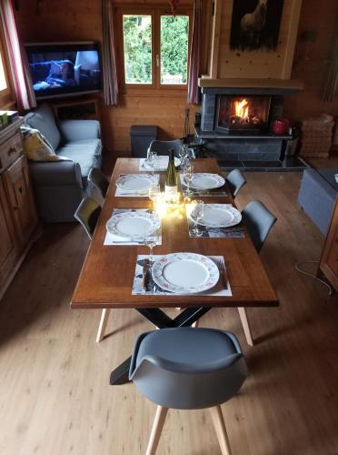 une salle à manger avec une table et une cheminée dans l'établissement Chalet Les Vosgiennes, à Le Valtin