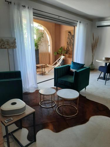 a living room with two chairs and two tables at Suites JM - Le temps d'une Escale (Jacuzzi & Vue Mer) in Hyères