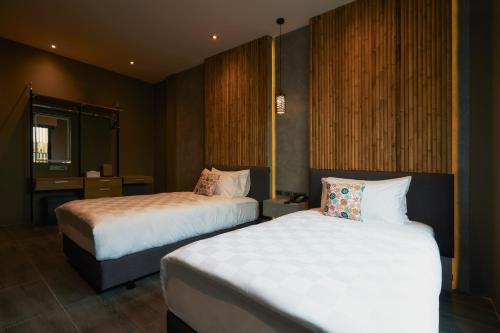 a hotel room with two beds and a mirror at Sand Dollar Boutique Hotel in Bang Sare