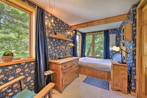 a bedroom with a bed and a desk and a window at Lakeside Iola Hideaway: Stunning Nature Views in Iola