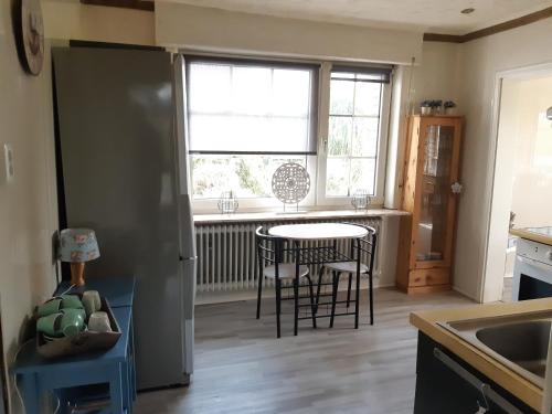 a kitchen with a table and chairs and a window at Monteurzimmer Ausma Boen 2 - Vakantiehuis Rust & Ruimte in Bunde