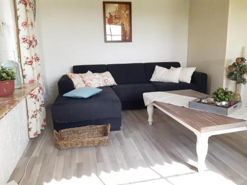 a living room with a couch and a coffee table at Monteurzimmer Ausma Boen 2 - Vakantiehuis Rust & Ruimte in Bunde
