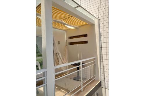 uma casa de banho com um espelho e paredes em azulejos brancos em Anexo da Cal em Torres